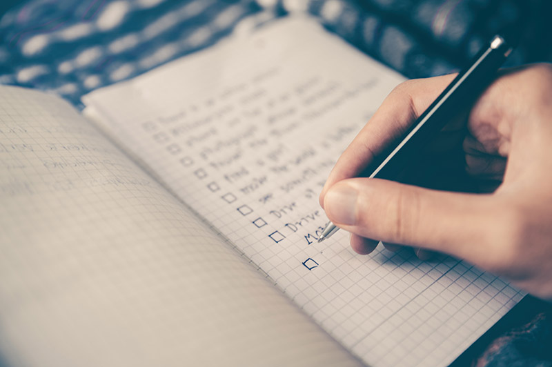 Pre-Travel Anxiety | Make Your Travel Jitters Work For You

photo: person writing a checklist in a grid notebook