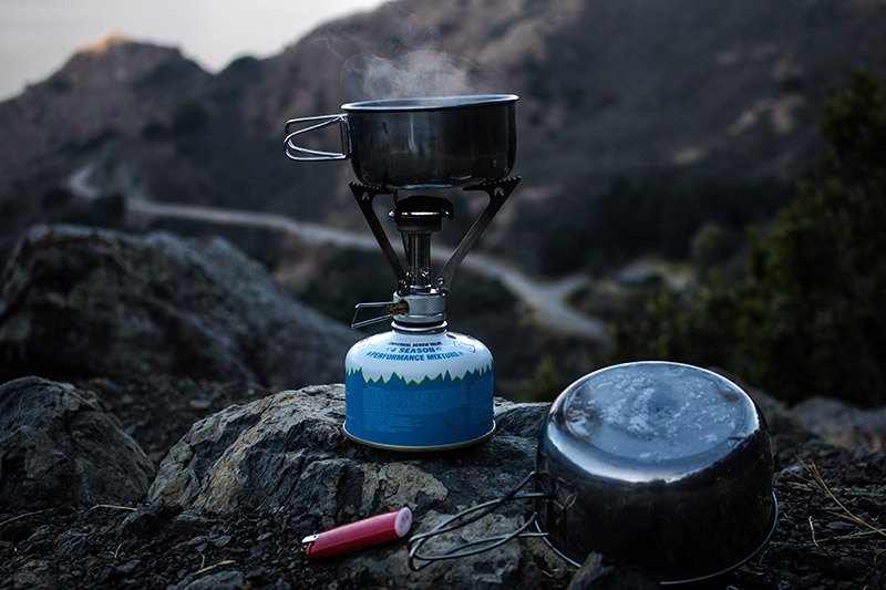 long distance hiking gear, pans and stove on a rock