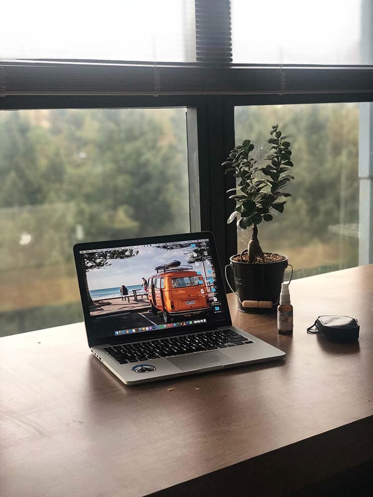 a laptop with an orange van at the beach on the screen